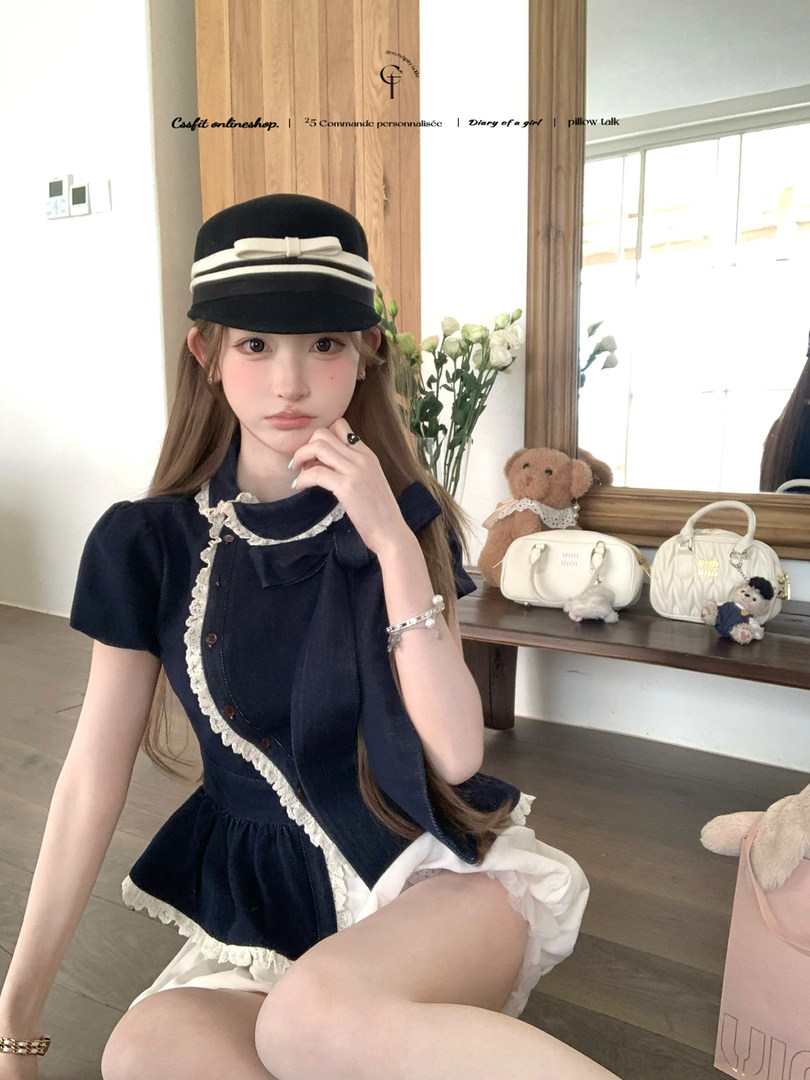 Model wearing a navy lace-trim dress and black hat indoors