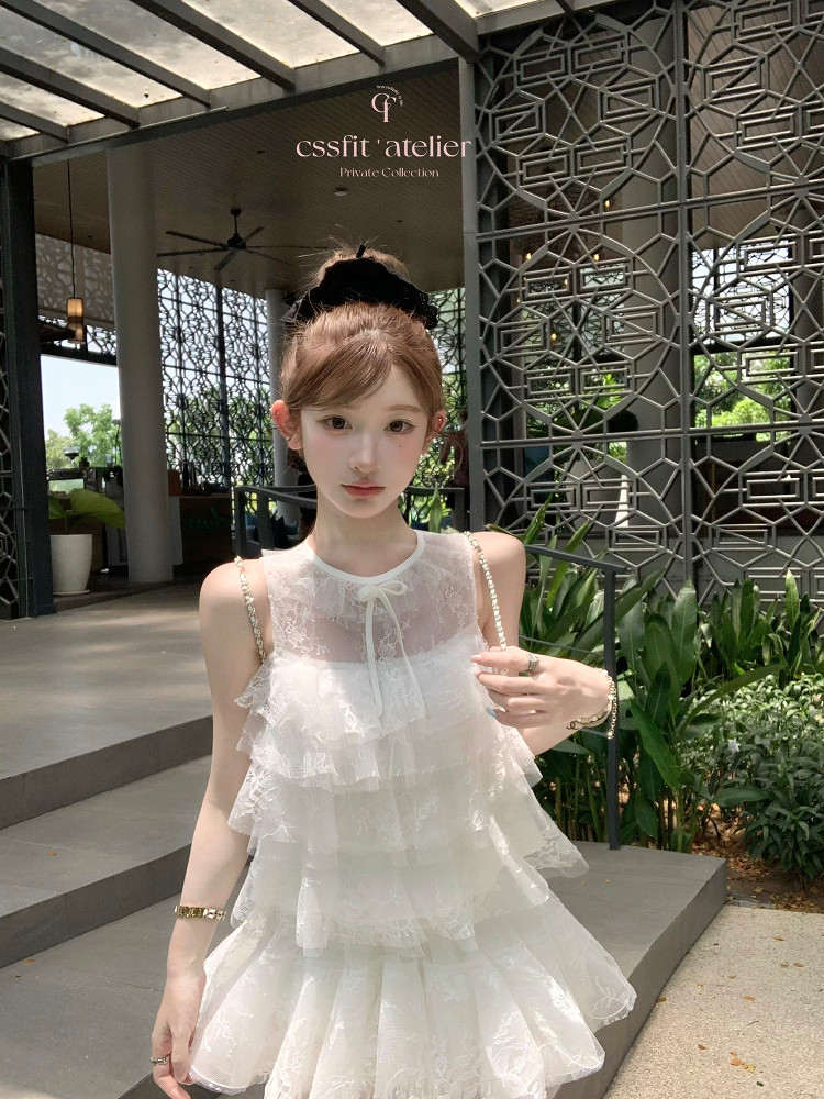 White tiered sleeveless lace dress worn by a model
