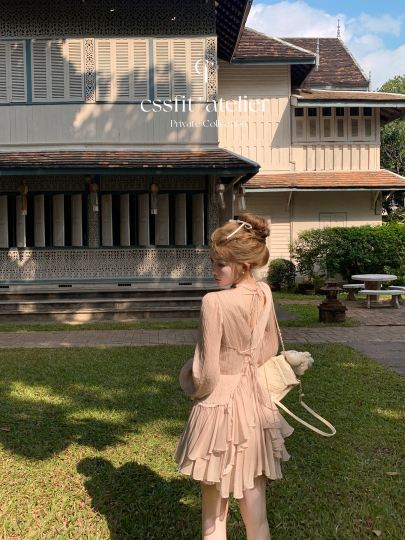 Model wearing a light pink ruffled dress outdoors