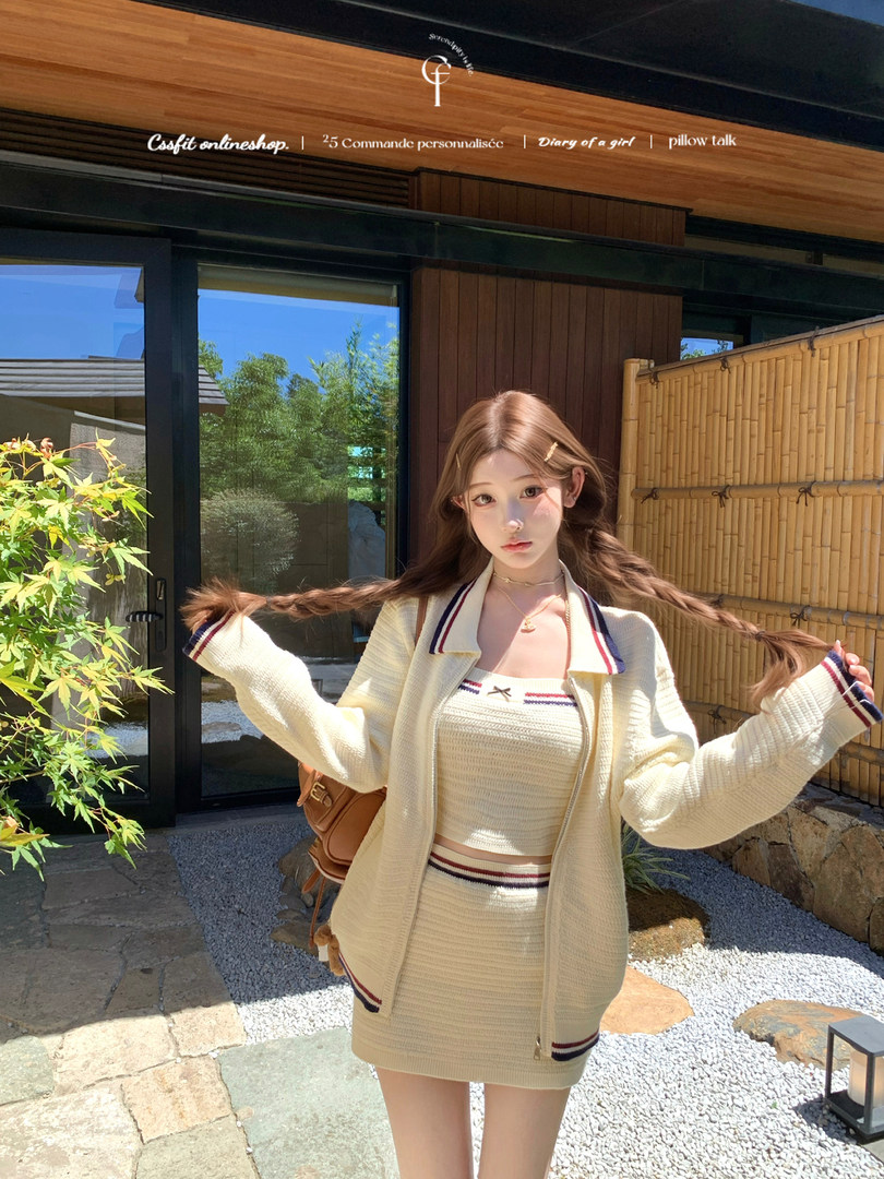 Woman wearing a cream knit two-piece outfit with striped trim outdoors