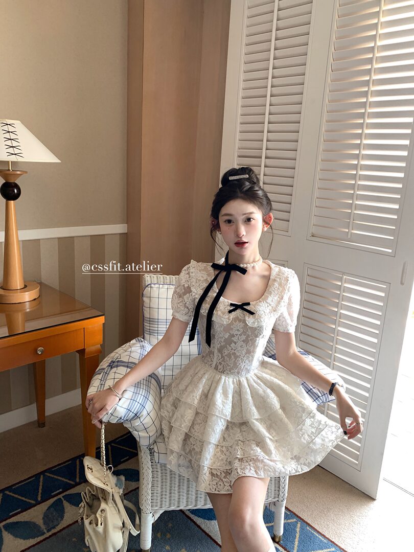 White lace short dress with black ribbon detail worn by a model