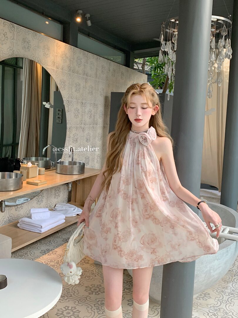 Model wearing a light pink floral halter mini dress