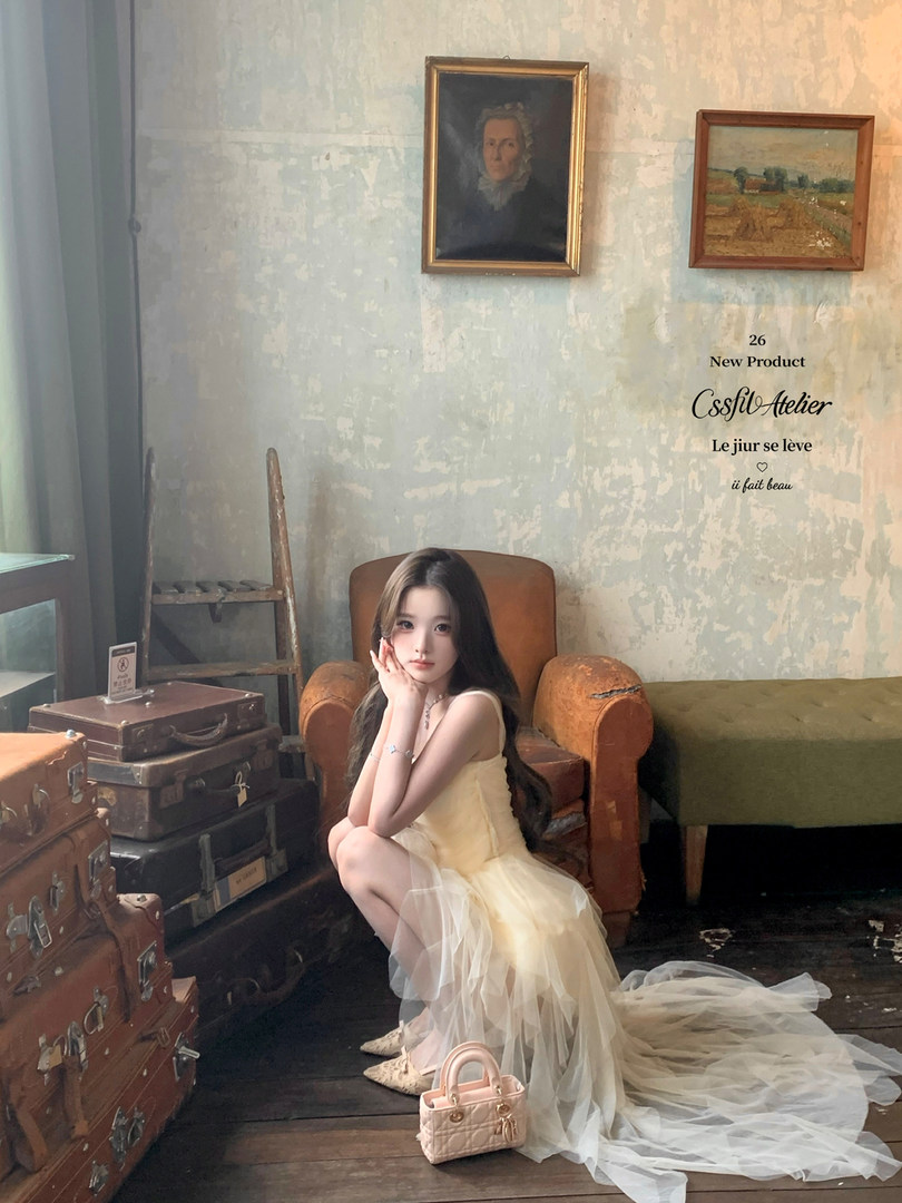 Model wearing a pale yellow tulle formal dress in an interior setting