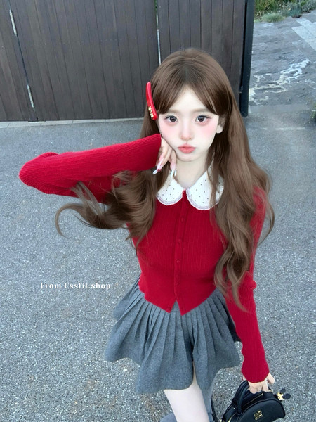 Woman wearing a red cardigan with a white collar and gray pleated skirt