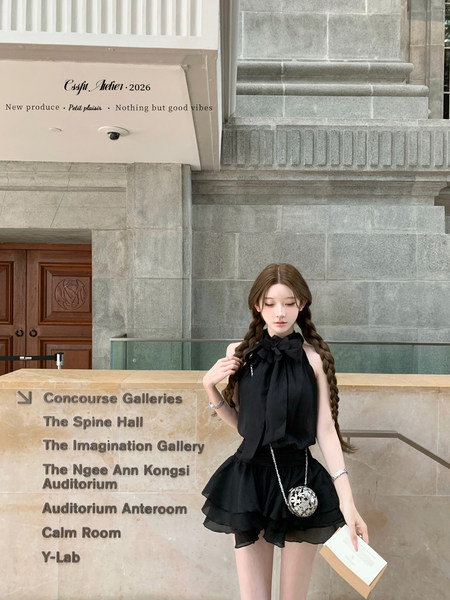Black halter top and ruffled skirt outfit worn by a model