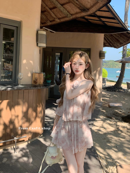 Model wearing a light pink floral two-piece outfit at a beach resort