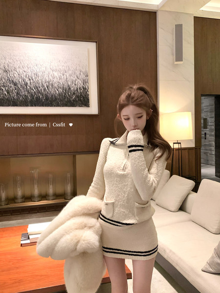 Model wearing a cream textured knit sweater and mini skirt set with black stripe trim