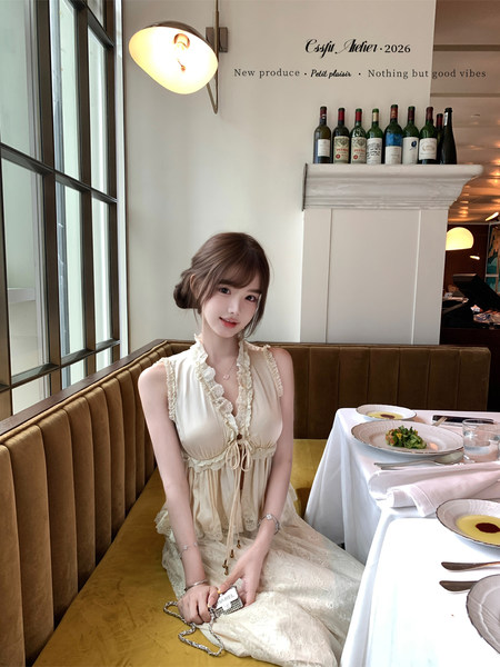 Woman wearing a cream ruffled lace dress seated in a restaurant