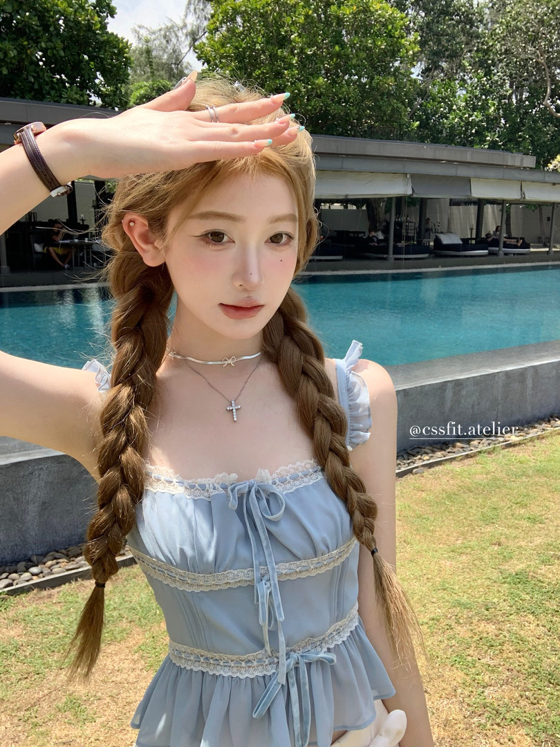 Light blue lace-trimmed dress worn by a model outdoors by a pool