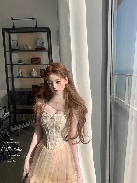 Model wearing a pastel strapless corset tulle dress in a sunlit room