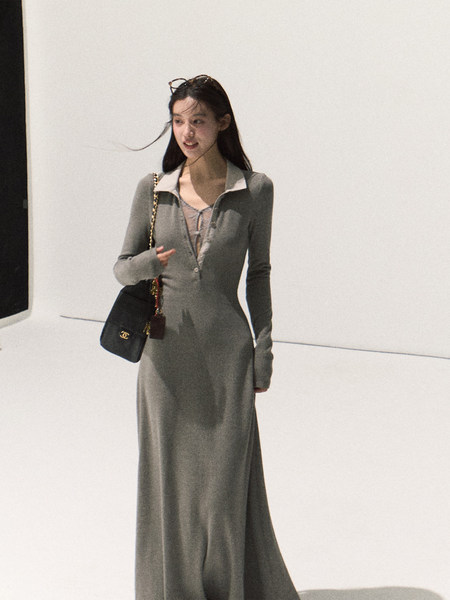 Gray long-sleeve maxi dress worn by a model with a black shoulder bag