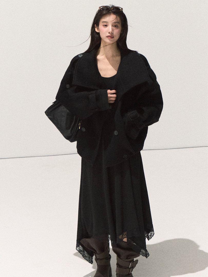 Black oversized coat and layered dark outfit worn by a model