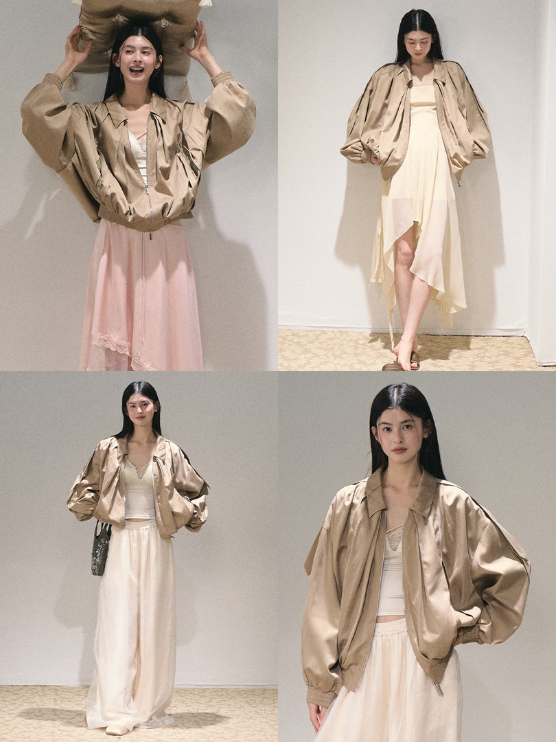 Beige satin bomber jacket worn with a light dress and skirt on a model