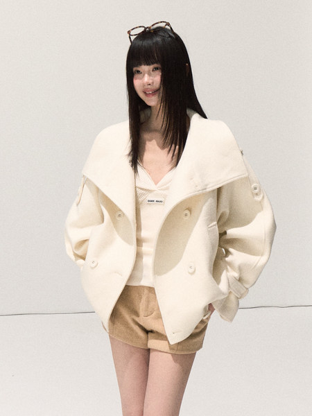 Model wearing a cream oversized jacket with shorts