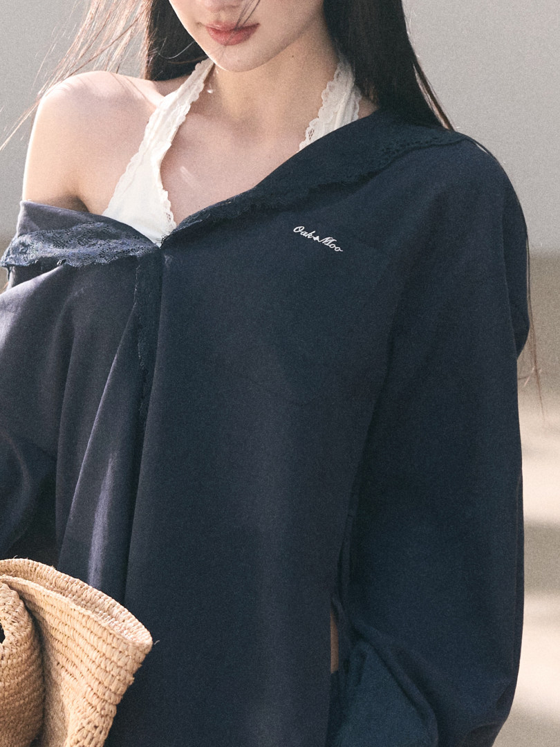Black oversized jacket worn by a model with a white lace top