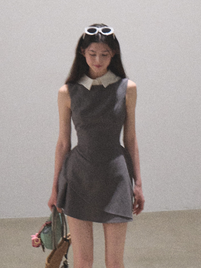 Model wearing a gray sleeveless mini dress with a white collar