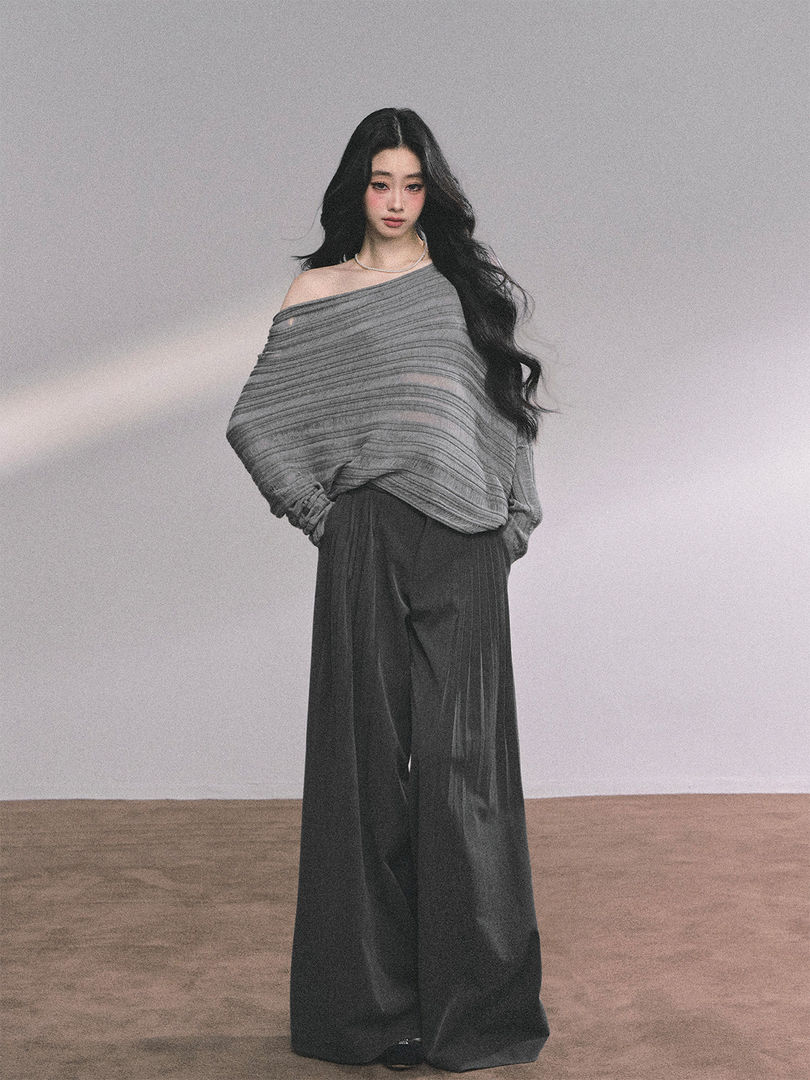 Model wearing a gray off-shoulder knit top with wide-leg dark pants