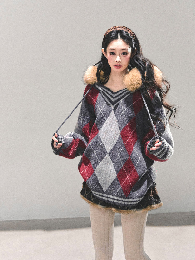 Model wearing an oversized argyle sweater with faux fur trim