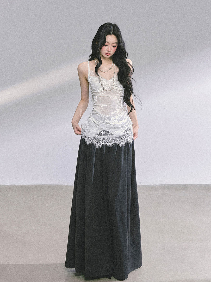 Model wearing a white lace camisole top with a long black skirt