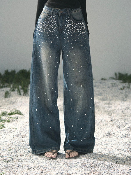 Wide-leg blue jeans with white dot embellishments worn by a model