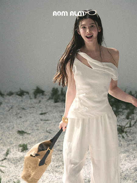 Woman wearing a white off-shoulder outfit on a beach