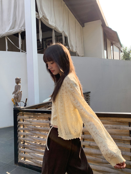 Model wearing a cream lace-knit long-sleeve sweater