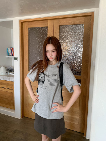 Woman wearing a gray graphic T-shirt with a printed design