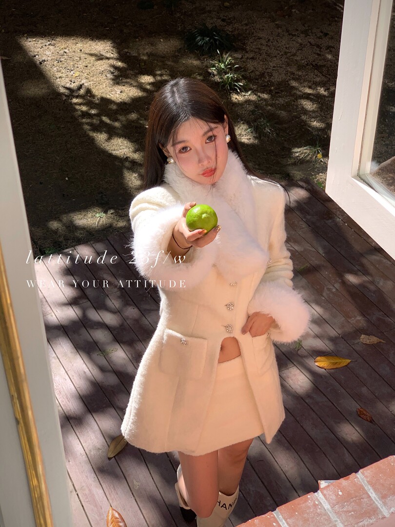 Woman wearing a white fuzzy coat and matching skirt outdoors