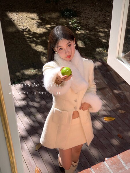 Woman wearing a white fuzzy coat and matching skirt outdoors