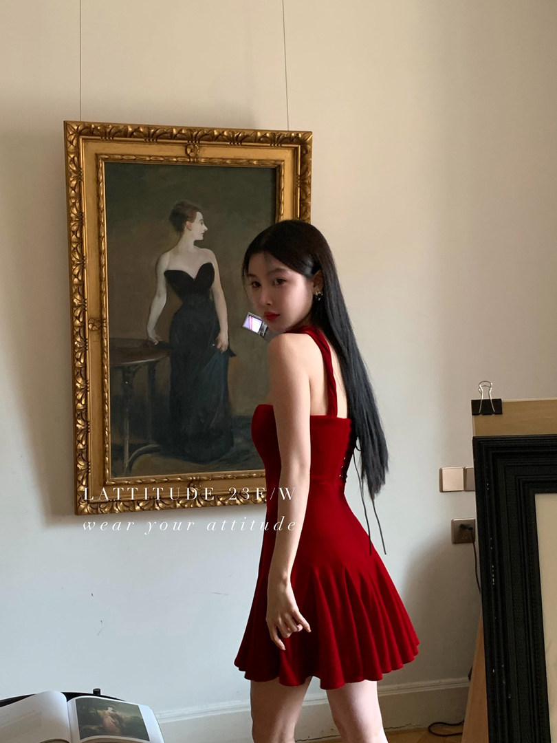 Woman wearing a red sleeveless mini dress indoors