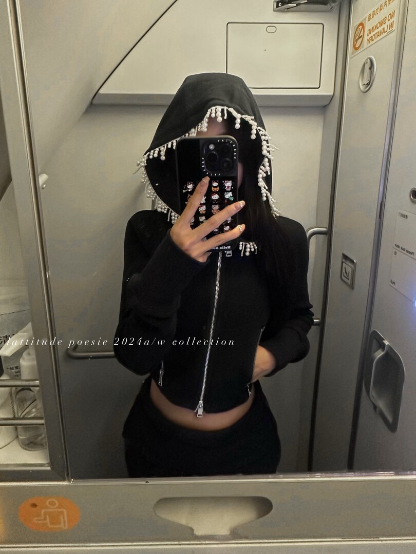 Black hooded zip-up top with pearl fringe detail worn by a model in a mirror selfie