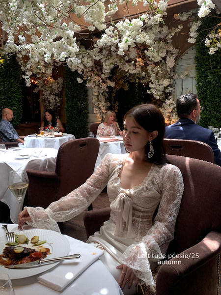 Woman wearing a cream lace long-sleeve dress at a restaurant