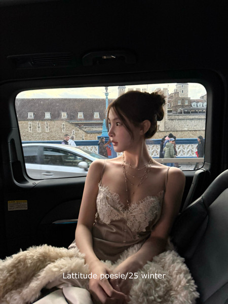 Woman wearing a beige lace-trim slip dress in a car