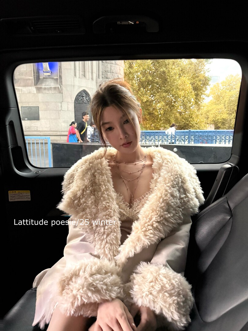 Woman wearing a cream faux fur coat in a car