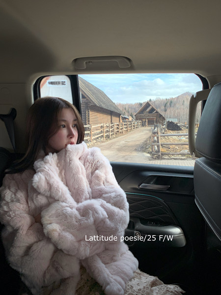Woman wearing a pale pink faux fur coat in a car