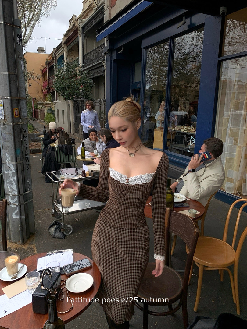 Woman wearing a brown gingham lace-trim dress at an outdoor cafe