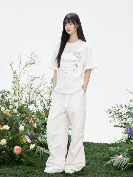 Model wearing a white graphic T-shirt and loose white pants