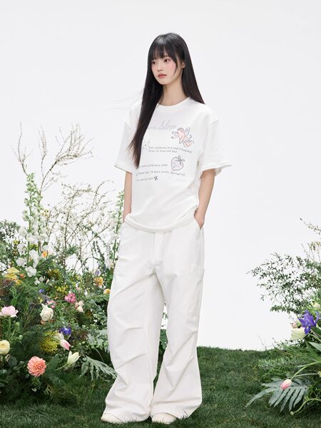 Model wearing a white graphic T-shirt and loose white pants