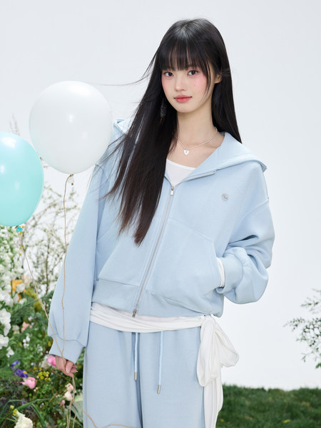 Model wearing a light blue zip-up hoodie and matching lounge pants