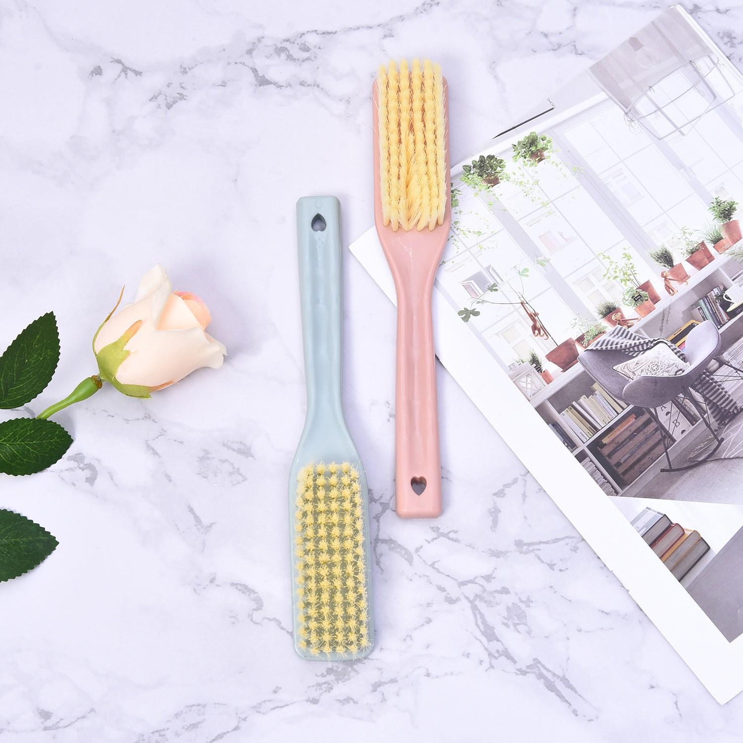 Gentle cleaning brush with long handle, featuring a hanging