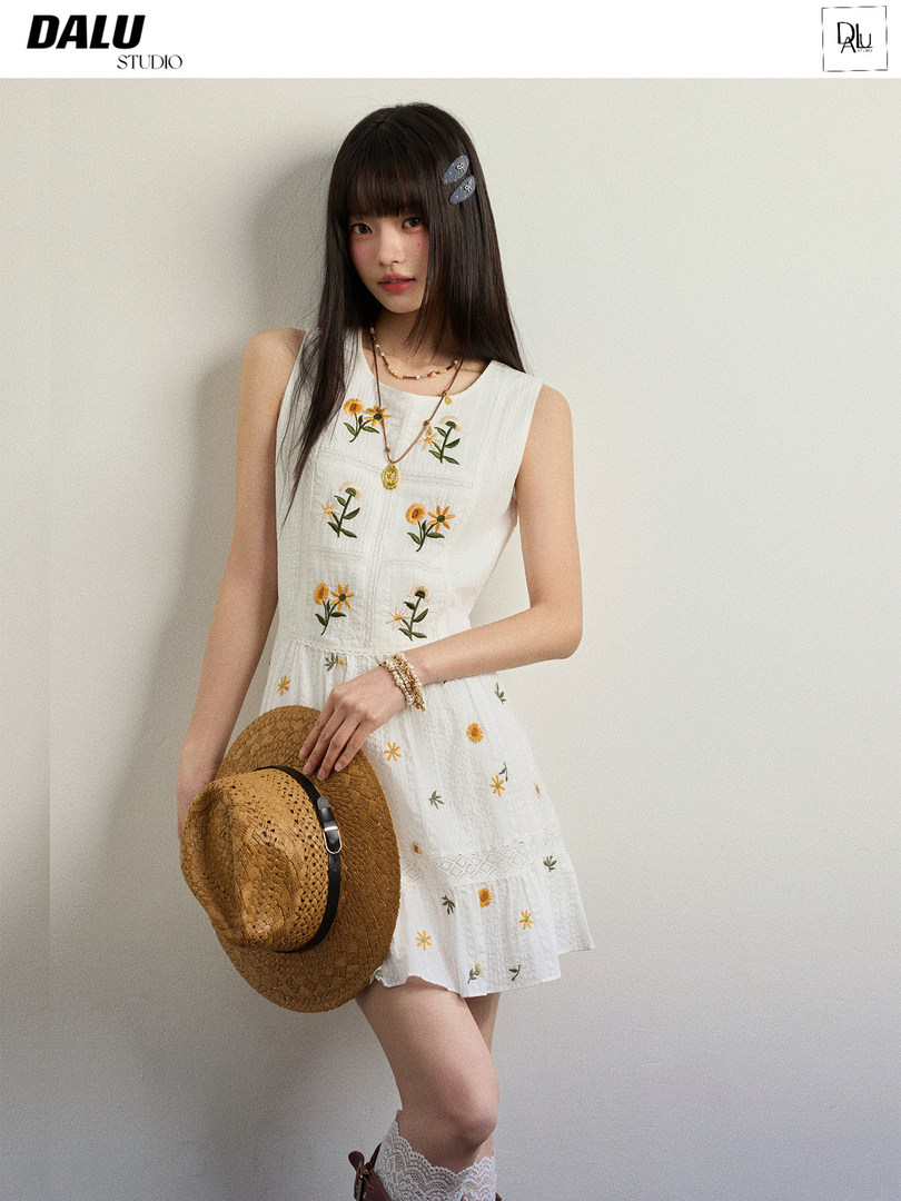 Model wearing a white floral sleeveless dress with a straw hat