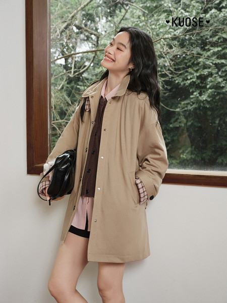 Woman wearing a beige long coat indoors