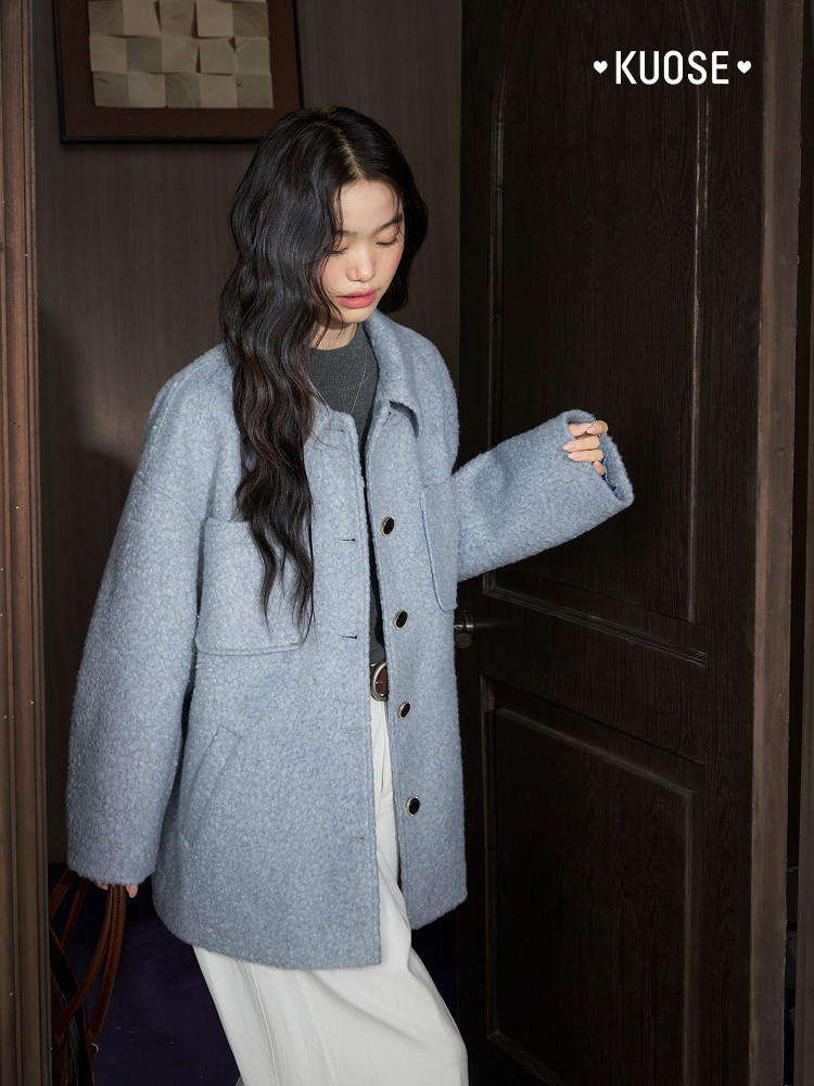 Model wearing a light blue oversized wool coat indoors