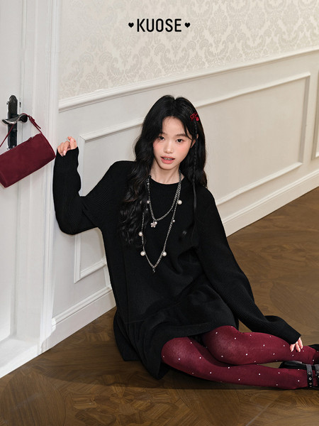 Black oversized knit sweater dress worn by a model with burgundy tights