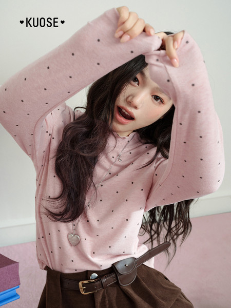 Pink polka-dot long-sleeve top worn by a model