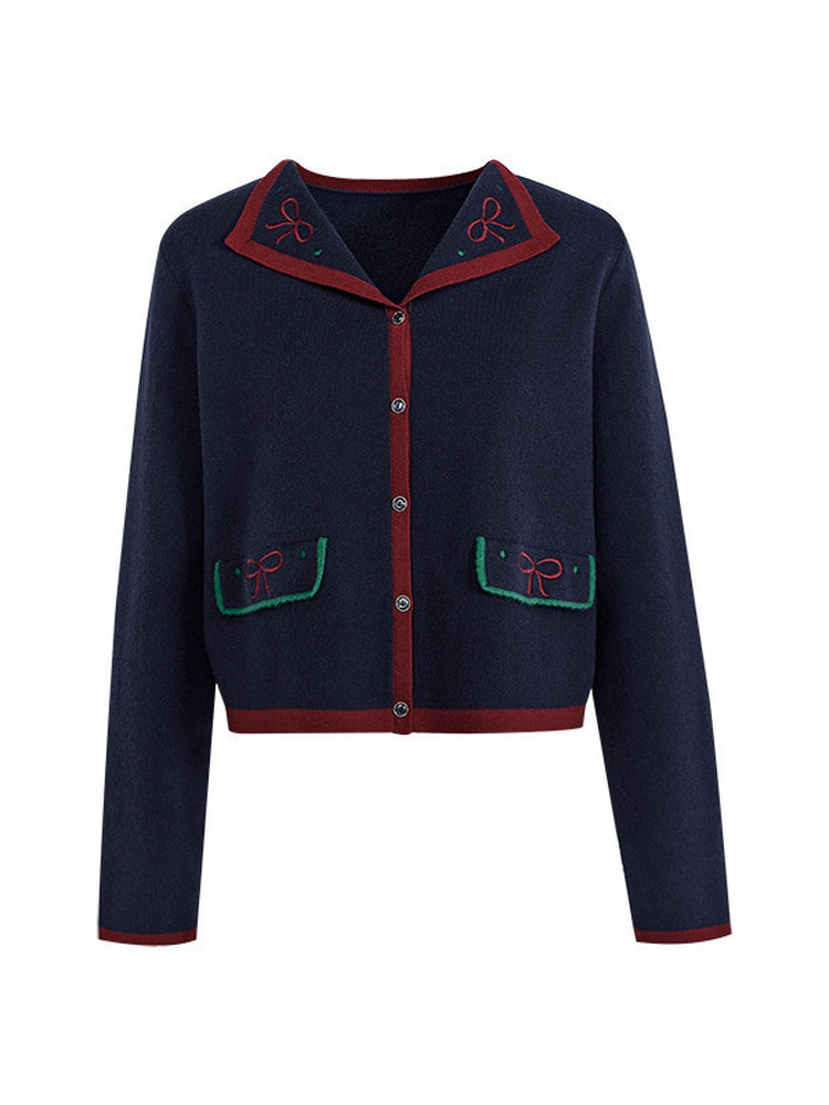Navy button-up cardigan with red and green trim laid flat on a white background