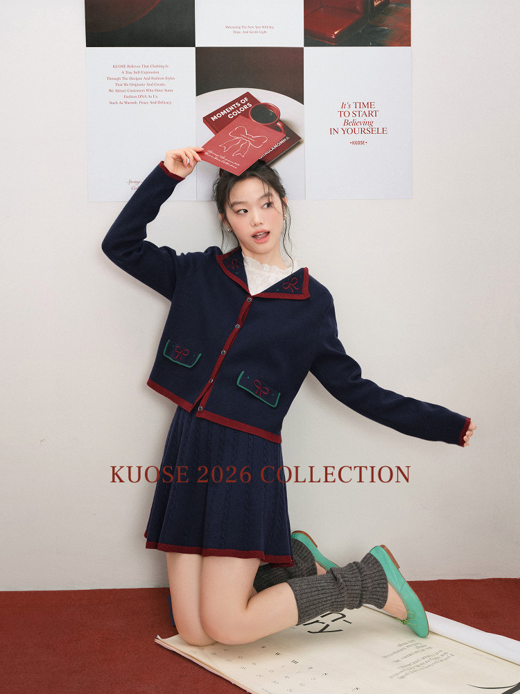 Model wearing a navy and red preppy cardigan with matching skirt and long socks
