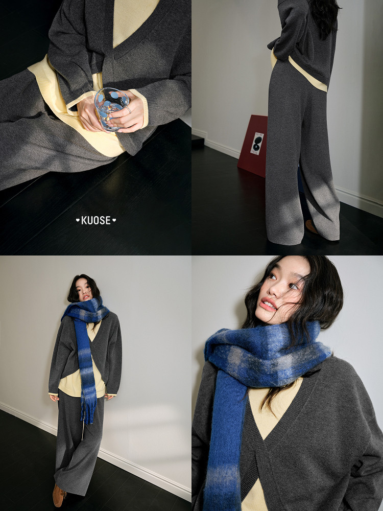 Model wearing a dark gray knit outfit with a blue plaid scarf