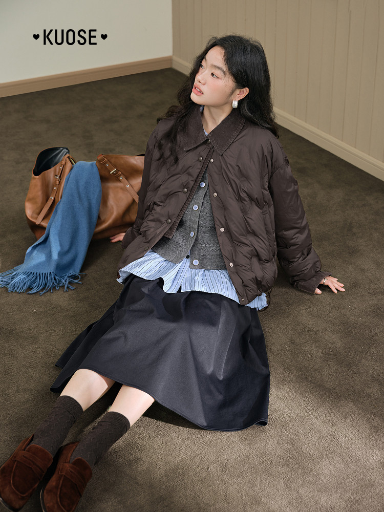 Fashion model wearing a dark quilted jacket with layered skirt and loafers