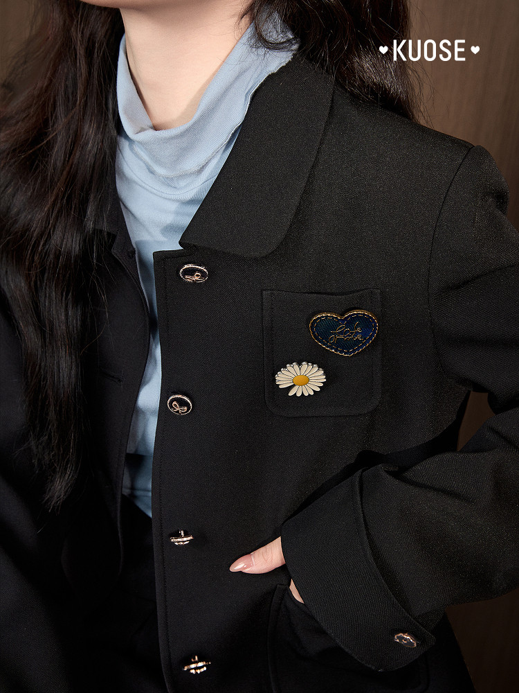 Black blazer jacket worn by a model with decorative pins
